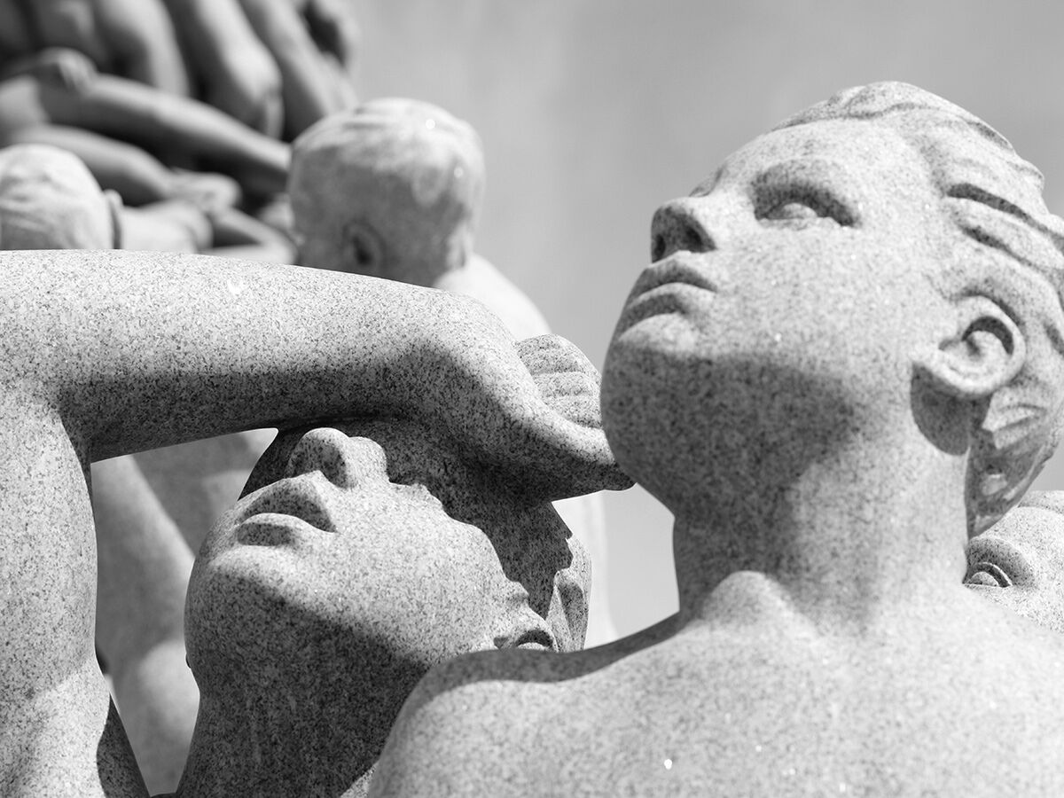 Schwarz-Weiß-Detailaufnahme von steinernen menschlichen Skulpturen im Vigeland Skulpturenpark, Oslo. Gesichter und Körper aus Granit.