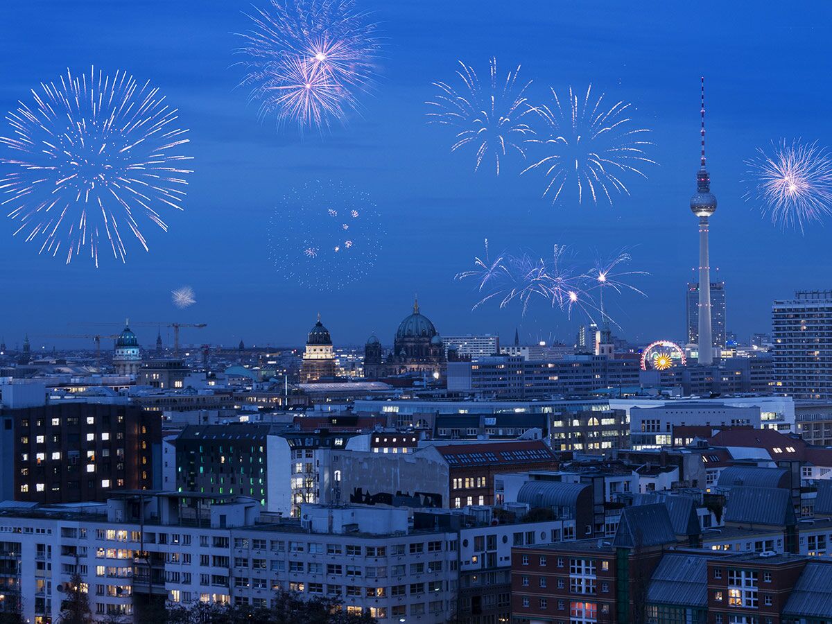 Beeindruckendes Feuerwerk über der Berliner Skyline bei Nacht, mit Fernsehturm, Dom und erleuchteten Gebäuden.