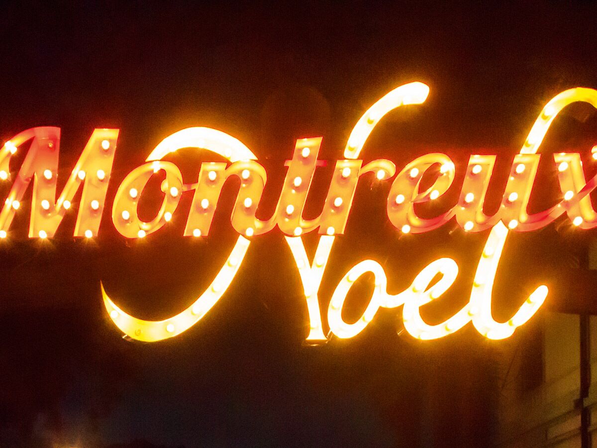 Hell leuchtendes Neon-Schild mit der Aufschrift „Montreux Noel“ im Dunkeln, symbolisiert festliche Weihnachtsstimmung.