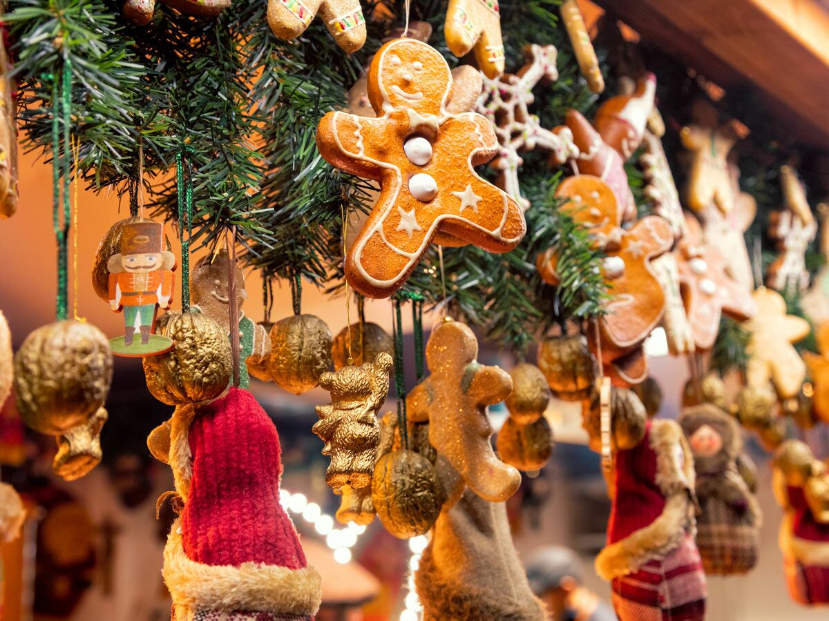 Nahaufnahme von Weihnachtsmarkt-Dekorationen mit Lebkuchenmännern, Tannenbaumzweigen, einem Nussknacker und weiteren Ornamenten.