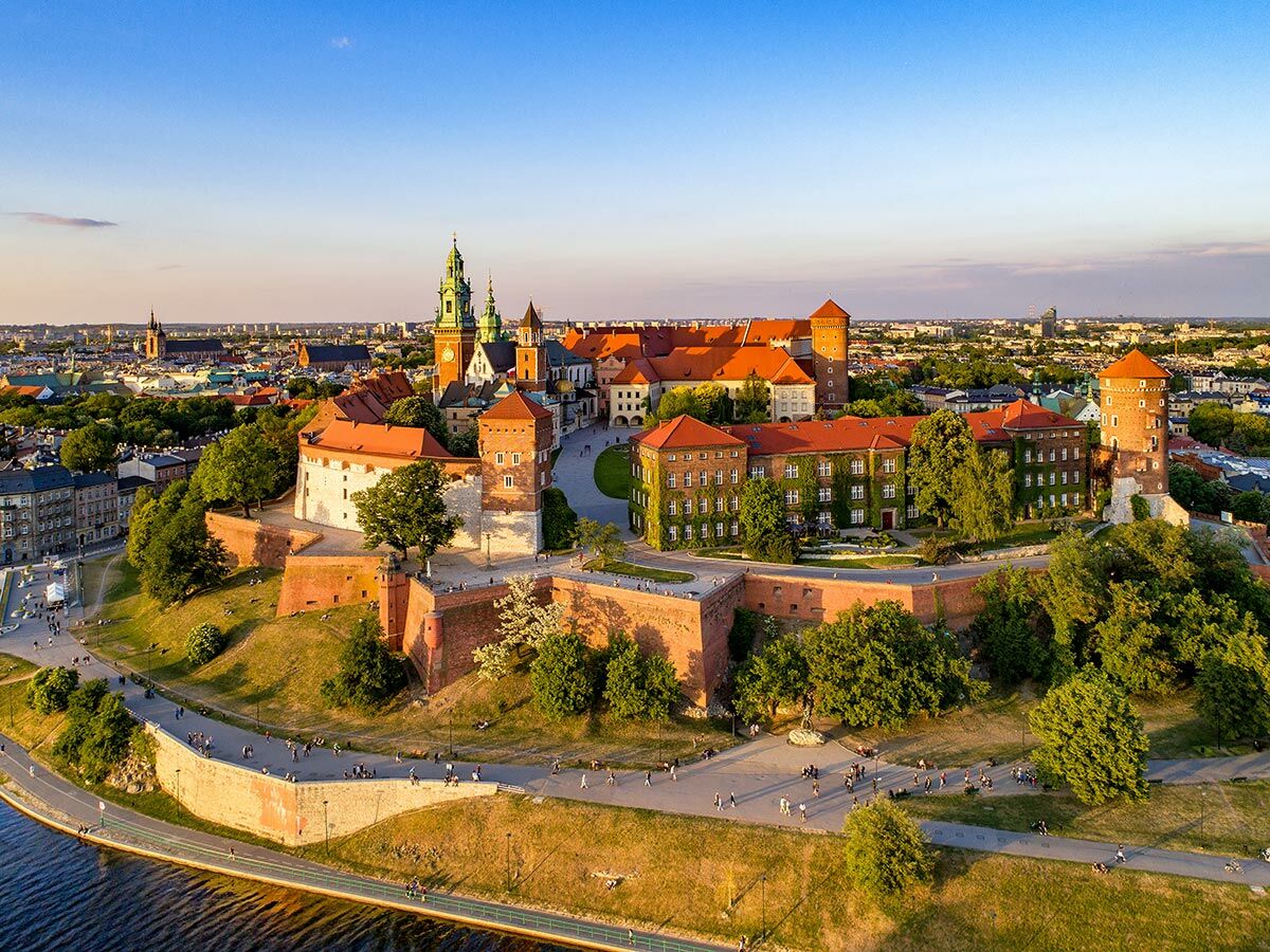 Panoramablick auf das Wawel Schloss und die Kathedrale in Krakau, Polen, am Fluss Wisła bei Sonnenuntergang.