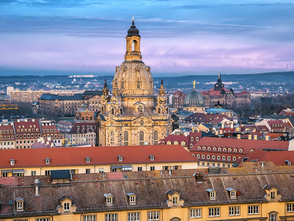 Historische Dresdner Frauenkirche im Zentrum der Altstadt bei Sonnenuntergang über roten Dächern. Panoramaansicht.