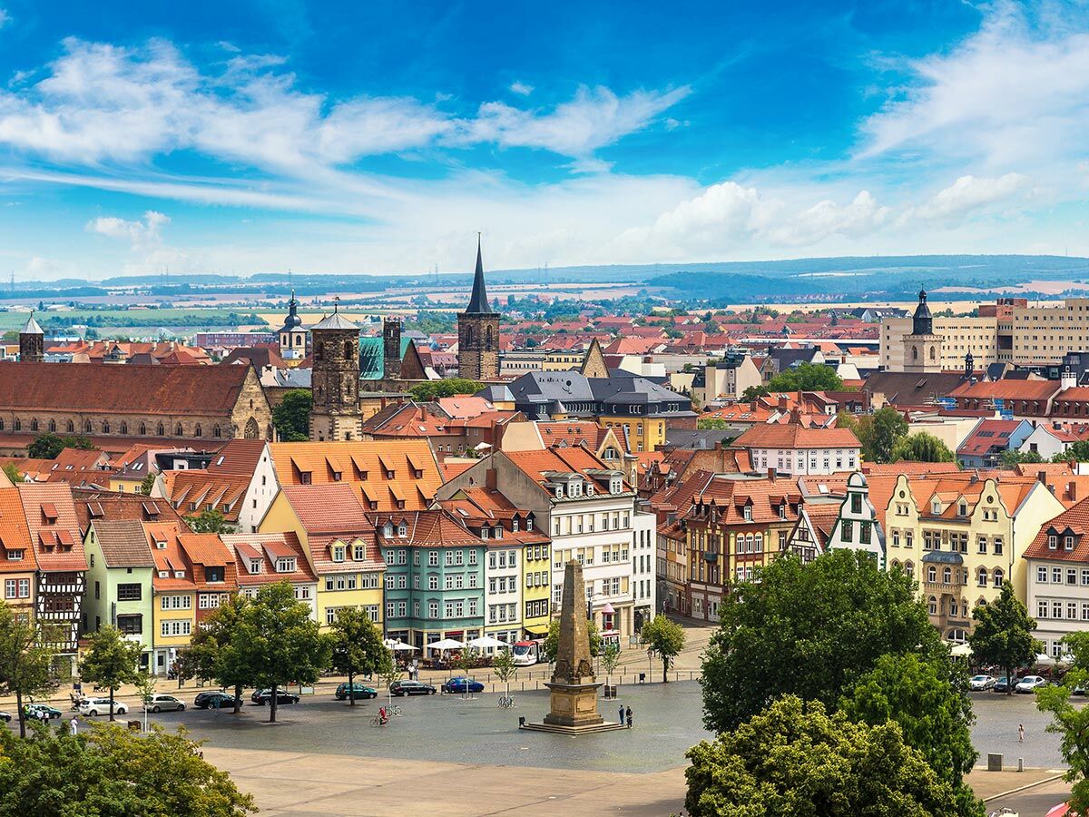 Panoramablick auf Erfurts historische Altstadt mit Dom, Severikirche, roten Dächern und Domplatz unter blauem Himmel.
