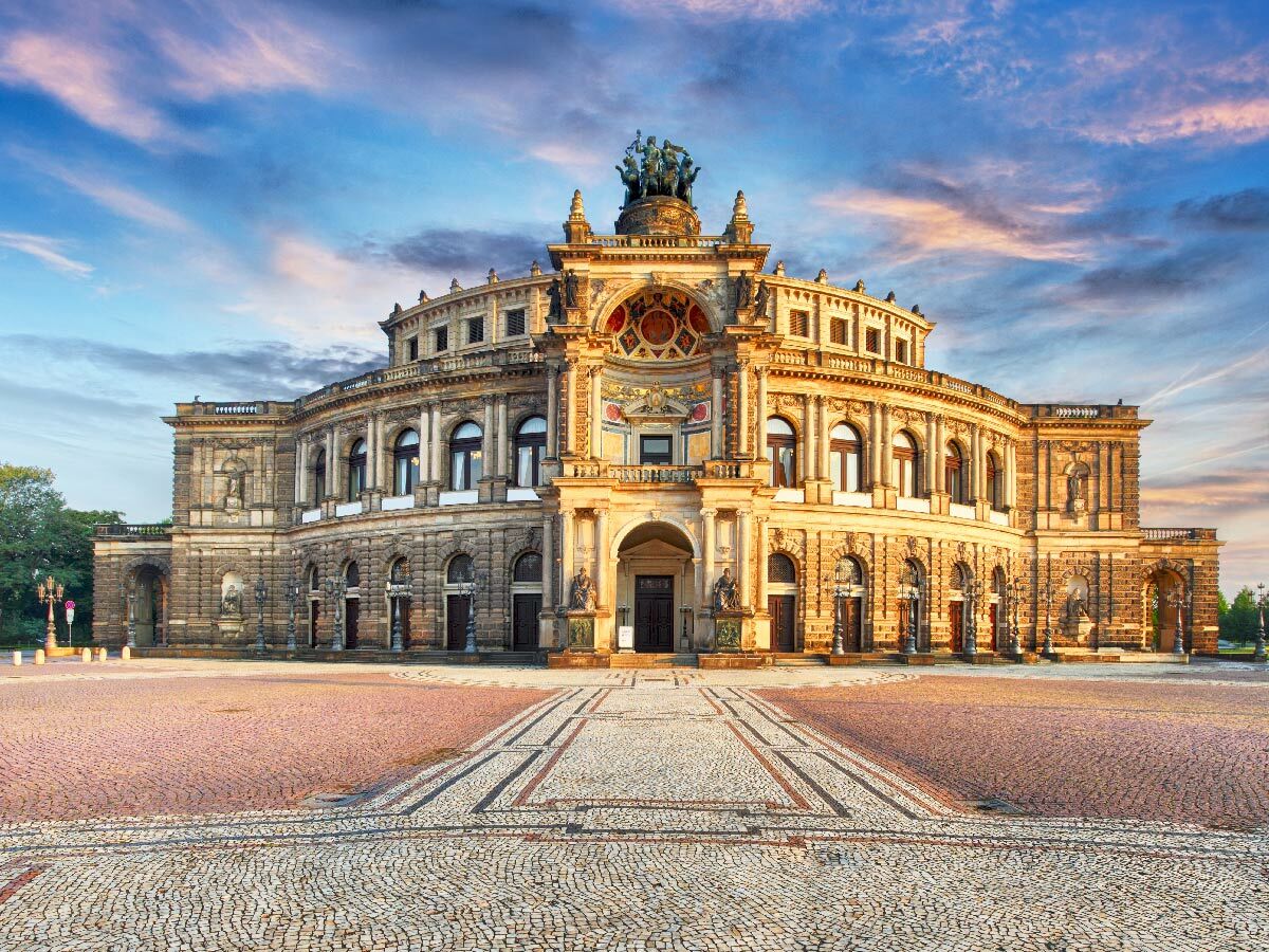 Die historische Semperoper in Dresden bei Sonnenuntergang, mit ihrer beeindruckenden Architektur und dem Vorplatz.