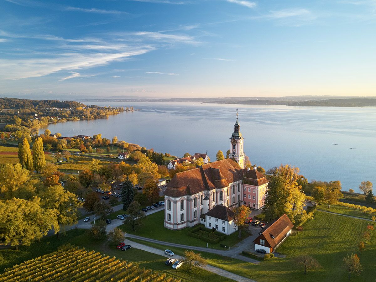 Barockkirche Kloster Birnau am Bodensee, umgeben von herbstlichen Weinbergen und leuchtenden Bäumen bei sonnigem Wetter.