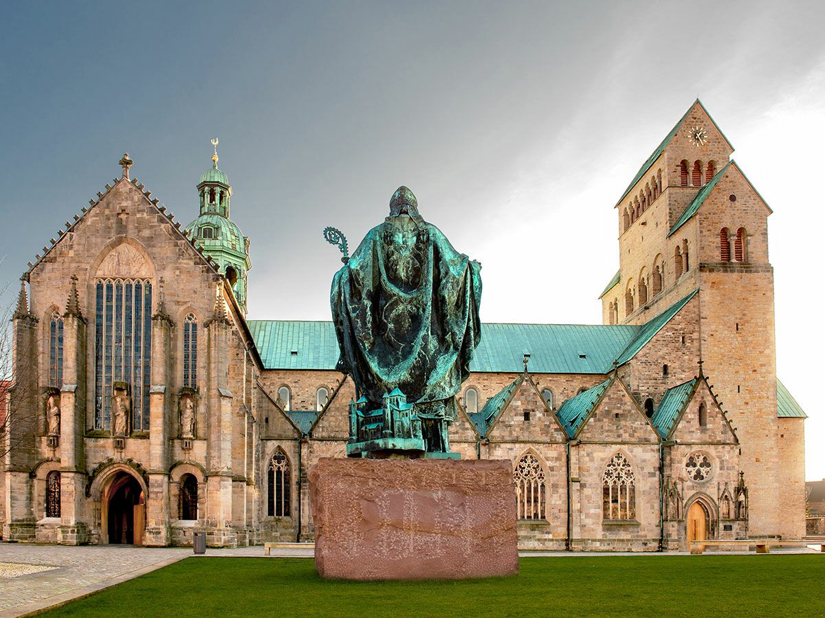 Blick auf den Hildesheimer Dom, eine romanische Kathedrale in Deutschland, mit einer Bronzestatue von Bischof Bernward.