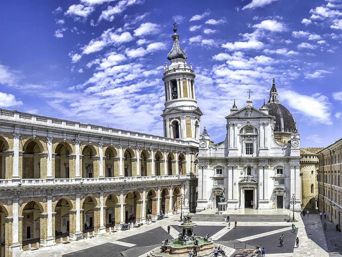 Loreto Heiligtum mit barocker Fassade, Glockenturm, Kuppel, langer Kolonnade und Brunnen auf Piazza della Madonna, Italien.