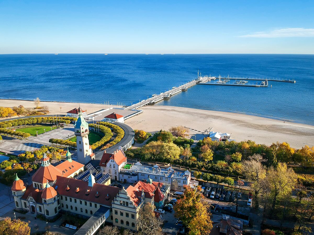 Luftbild von Sopot mit der langen Seebrücke, Strand, Spa-Haus und Leuchtturm an der polnischen Ostseeküste im Herbst.