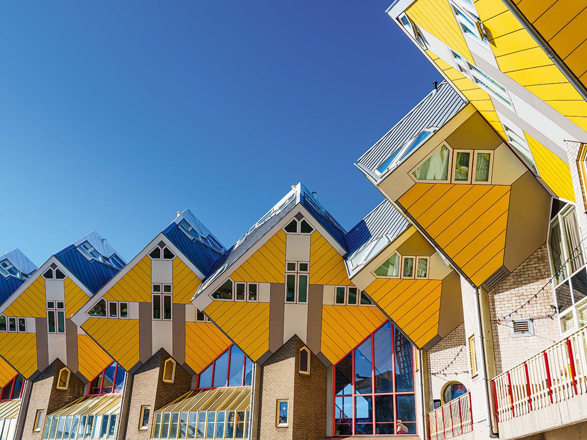 Blick auf die ikonischen gelben Kubuswoningen in Rotterdam unter strahlend blauem Himmel, moderne Architektur der Niederlande.