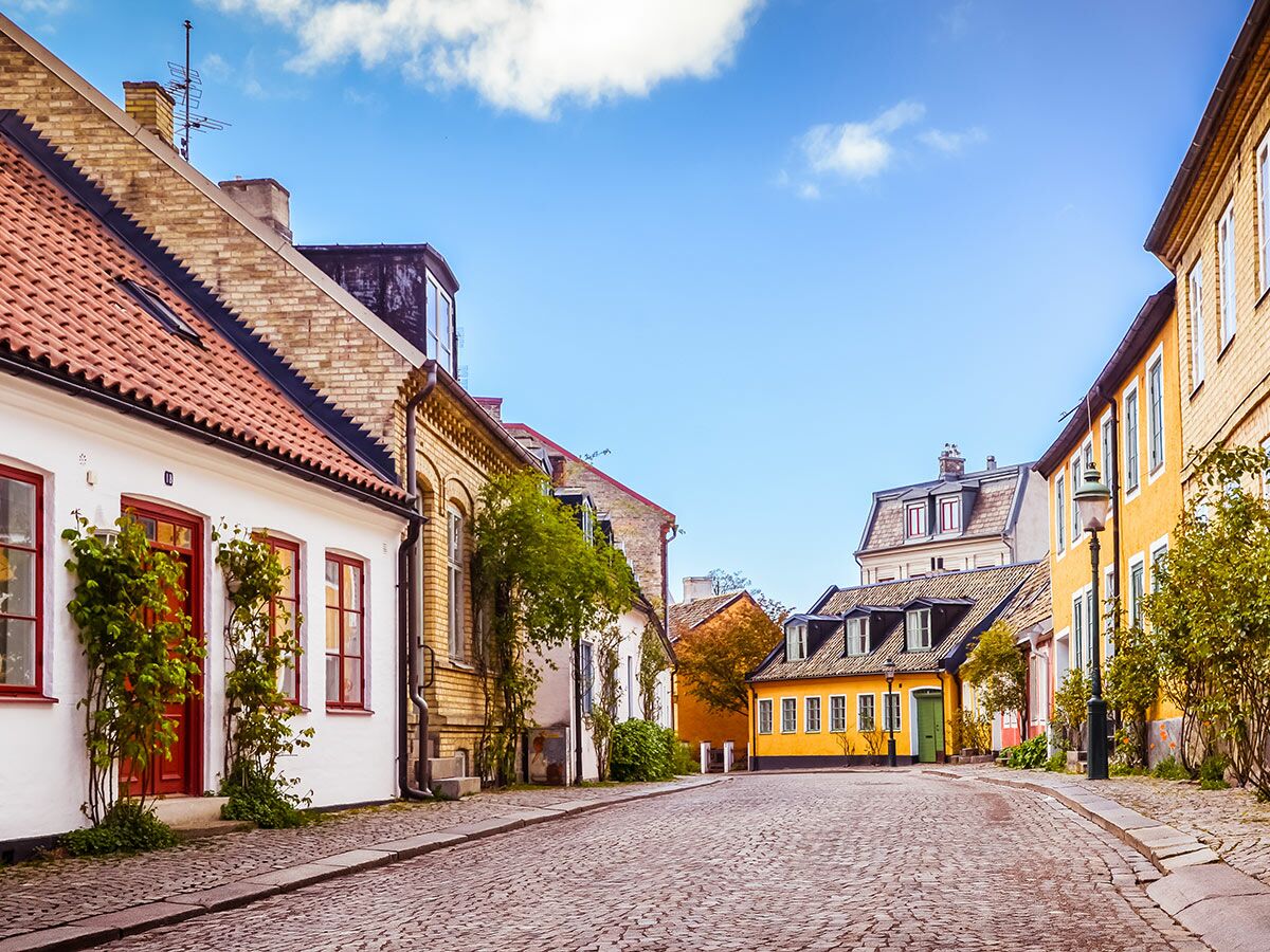 Malerische Gasse in einer europäischen Altstadt mit traditionellen Häusern, roten Ziegeldächern und blauem Himmel.