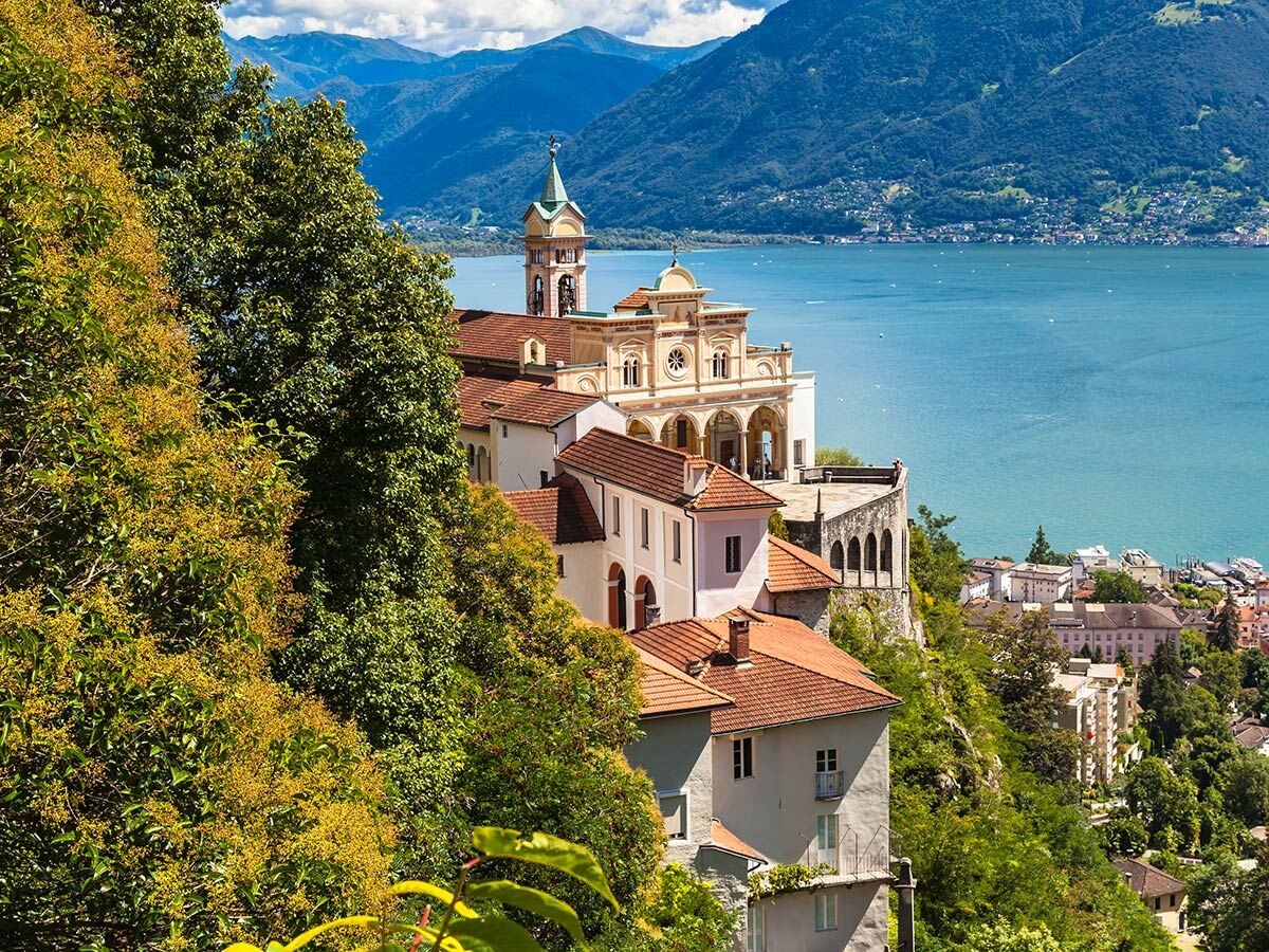 Wallfahrtskirche Madonna del Sasso mit Glockenturm am Hang über dem Lago Maggiore und Bergen in Locarno, Schweiz.
