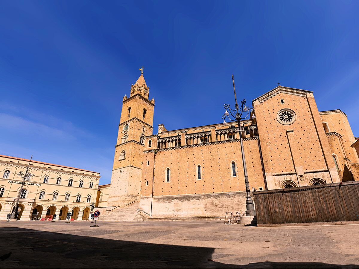 Historischer Dom San Pietro Campobasso, Italien, mit hohem Glockenturm und Justizpalast am Platz unter blauem Himmel.