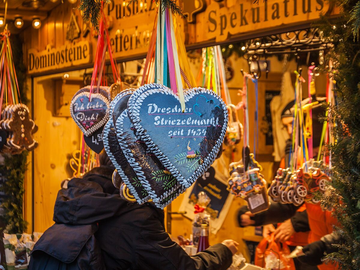 Lebkuchenherzen am Dresdner Striezelmarkt mit Schriftzug "seit 1434" und "Ich liebe Dich", umgeben von festlicher Deko.