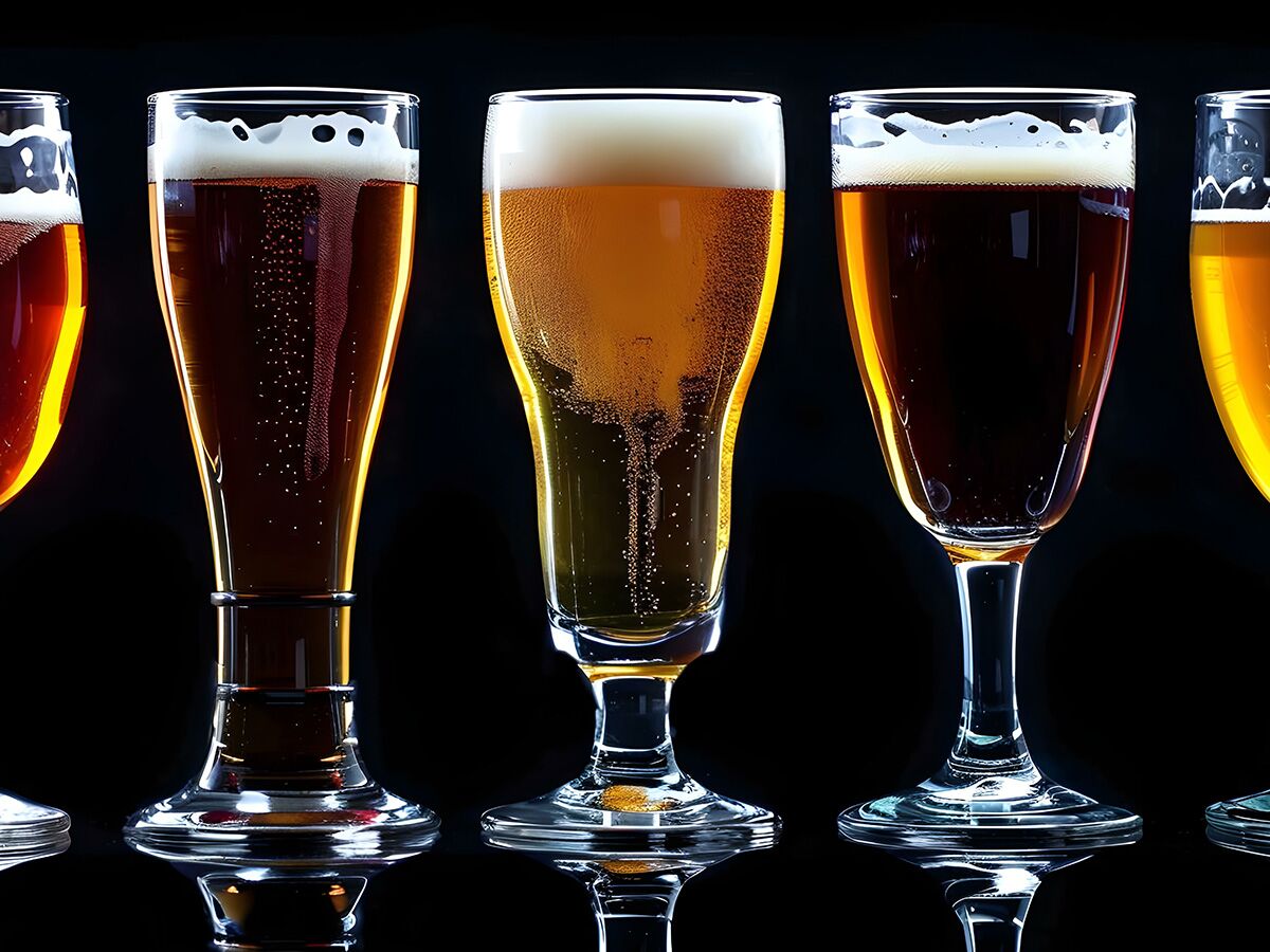 Fünf verschiedene Biergläser mit goldfarbenem und dunklem Bier, Schaumkrone und aufsteigenden Bläschen vor schwarzem Hintergrund.