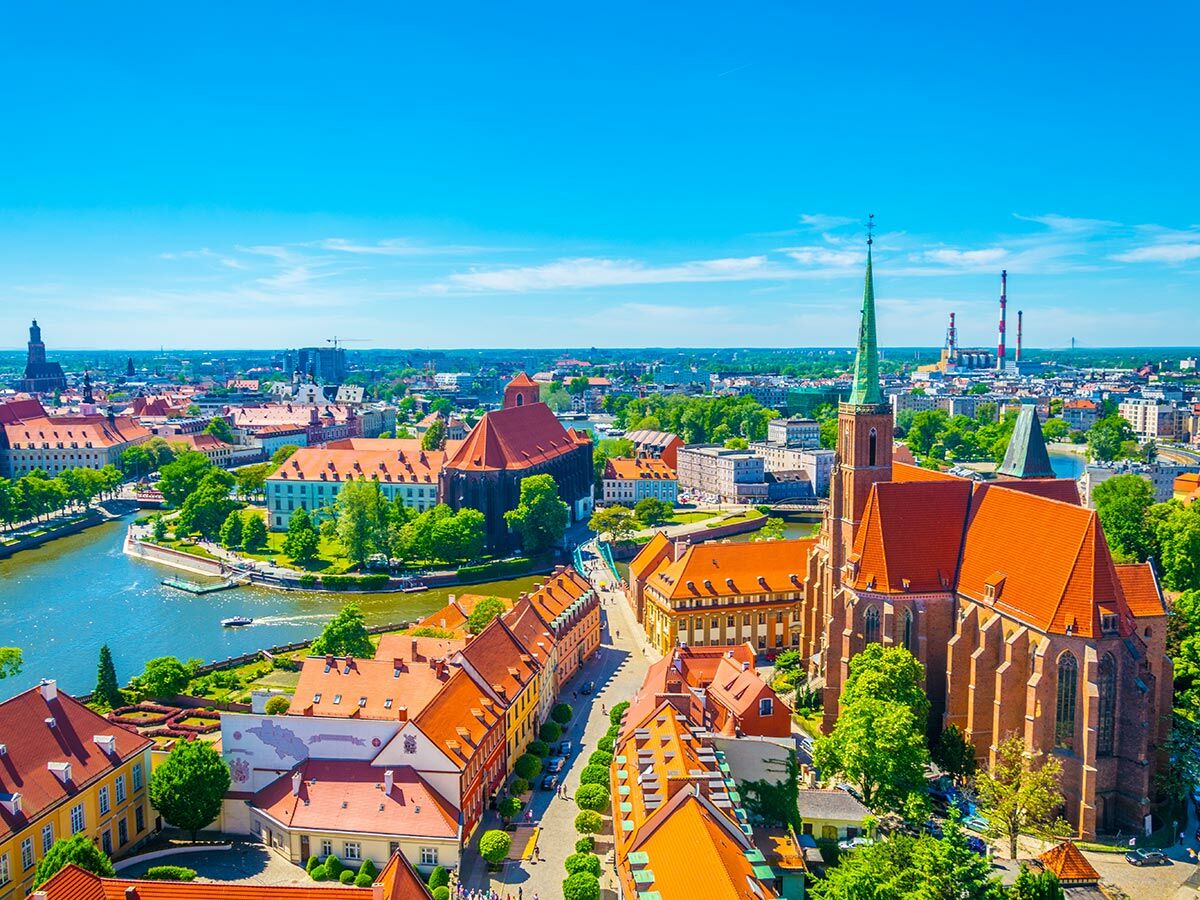 Luftaufnahme von Breslau mit historischer Architektur, der Oder und der Kathedrale auf einer Insel unter blauem Himmel.