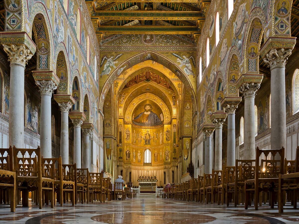 Die prächtige Innenansicht der Kathedrale von Monreale auf Sizilien, geprägt von goldenen byzantinischen Mosaiken und hohen Säulen.