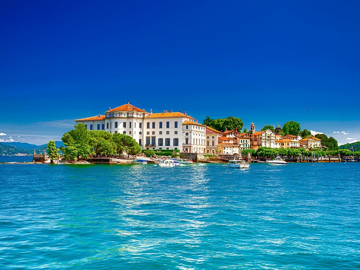 Isola Bella mit Borromäischem Palast, Villen und terrassierten Gärten am türkisfarbenen Lago Maggiore unter blauem Himmel in Italien.
