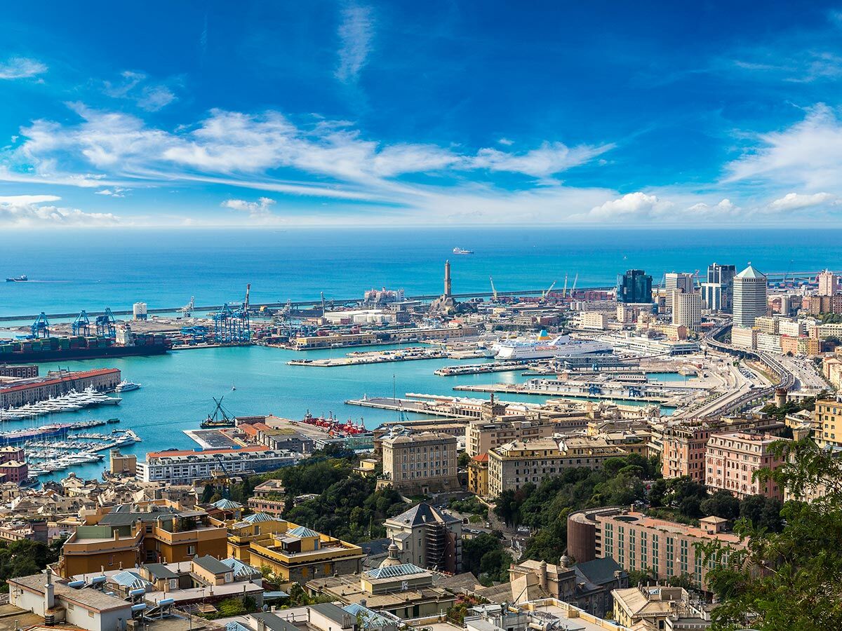 Panoramablick auf den Hafen von Genua, Italien, mit Frachtschiffen, Kreuzfahrtschiffen, Yachten und der historischen Stadtkulisse.