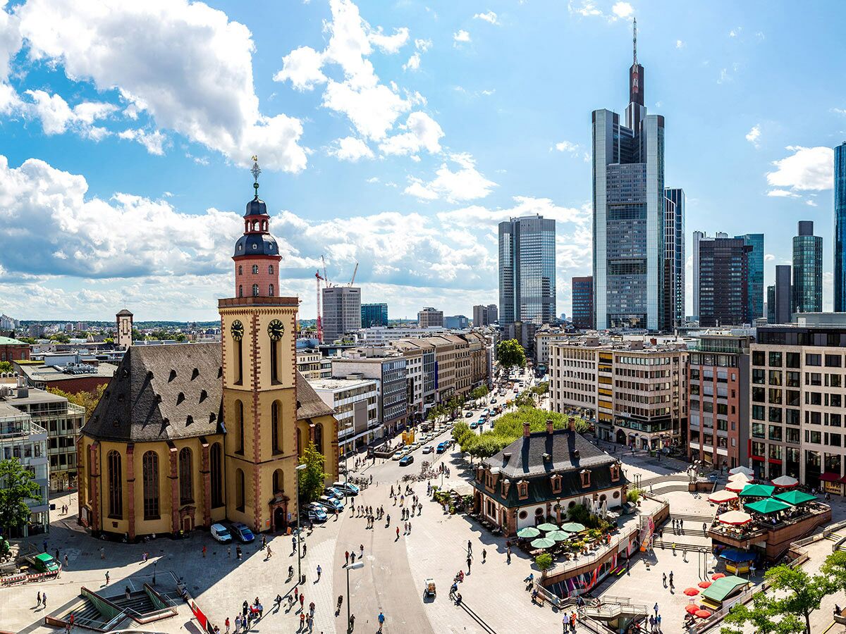 Panoramablick auf Frankfurts Paulskirche, belebten Platz und moderne Skyline mit Wolkenkratzern an sonnigem Tag.
