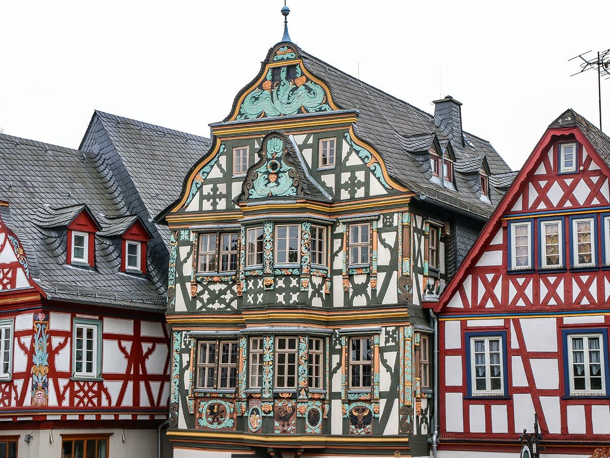 Bunte historische Fachwerkhäuser in einer deutschen Altstadt mit aufwendigen Verzierungen, Giebeln und Schieferdächern.