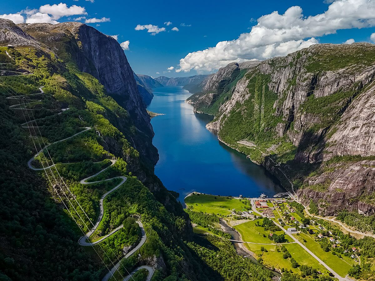 Luftbild des Lysefjords in Norwegen mit dramatischer Serpentinenstraße an der Bergflanke und Dorf Lysebotn am Fjordende.