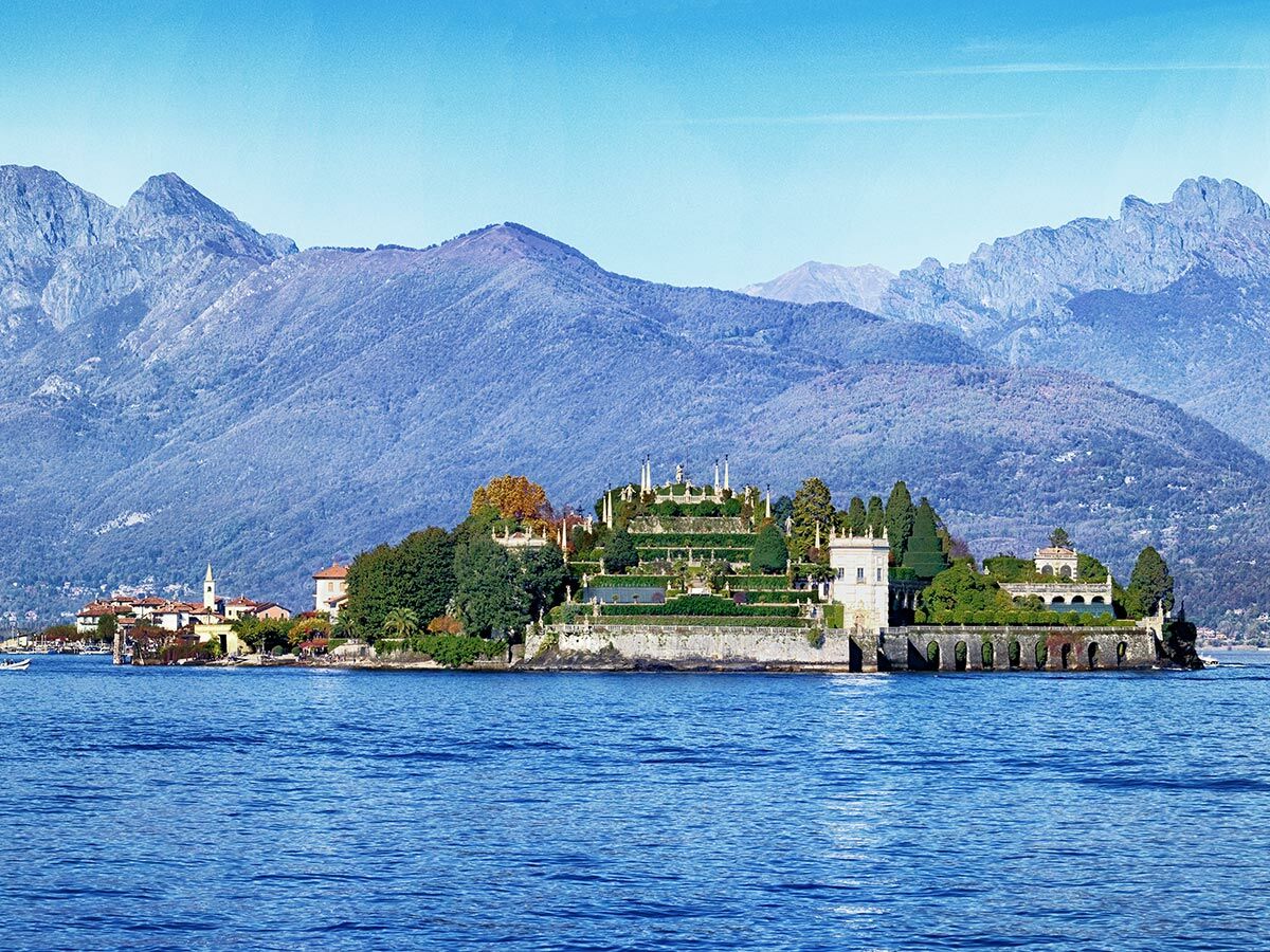 Panoramablick auf Isola Bella am Lago Maggiore mit Borromäischen Palast, terrassierten Gärten und Bergen.