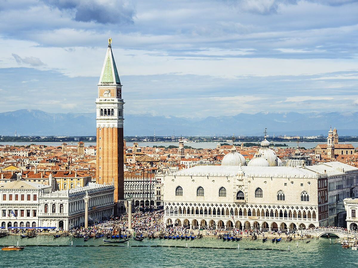 Luftbild von Venedig mit Markusplatz, Campanile, Dogenpalast und Touristenmassen, umgeben von Wasser und Gebäuden.