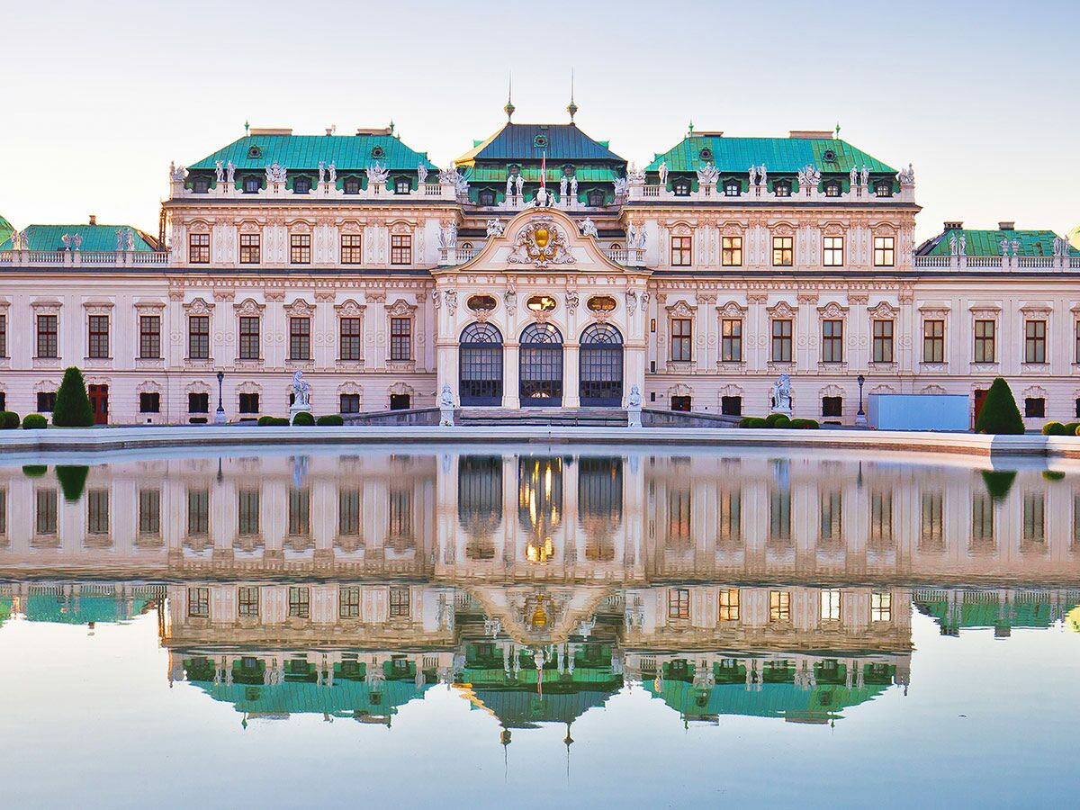 Barockes Belvedere Schloss in Wien mit grünen Dächern und perfekter Reflexion im Wasserbecken, bei Sonnenlicht.