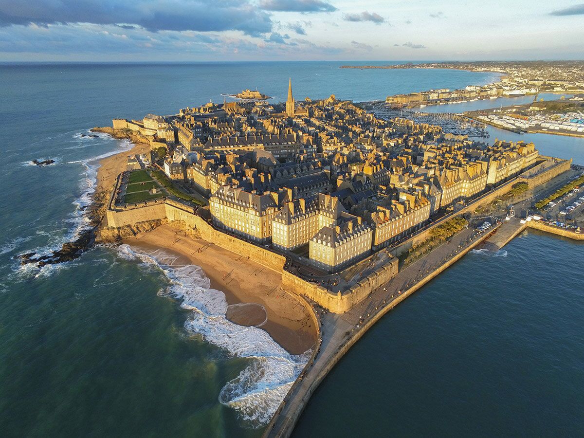 Luftbild von Saint-Malo, Bretagne, Frankreich, mit der historischen ummauerten Stadt, Stränden und Hafen bei Sonnenuntergang.