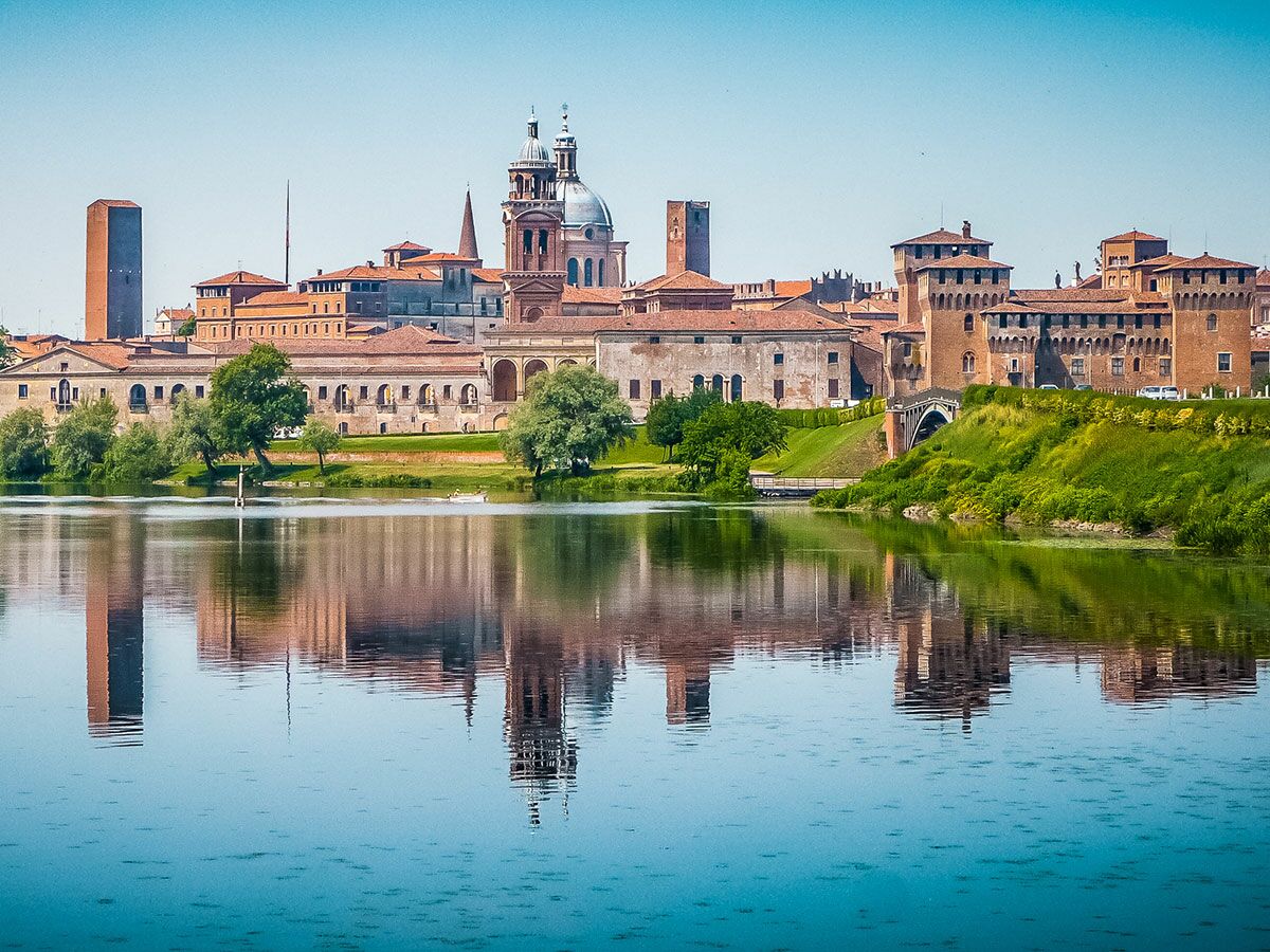 Historische Stadt Mantua, Italien, mit Kathedrale, Türmen und alten Gebäuden, spiegelt sich im blauen See. Malerische Stadtszene.