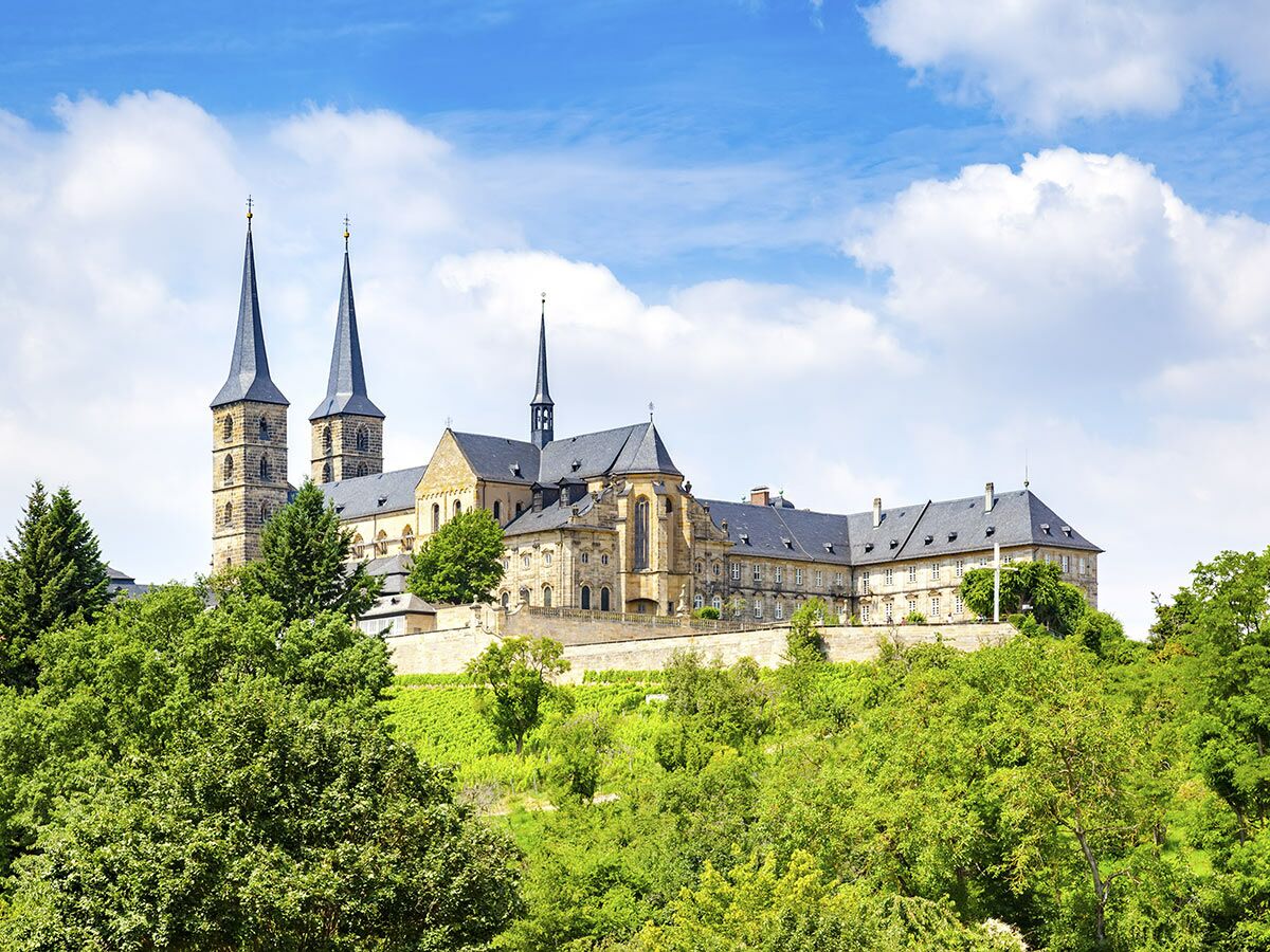 Historisches Michaelsberg Kloster und Bamberger Dom auf grünem Hügel in Bamberg, Deutschland, bei sonnigem Wetter.