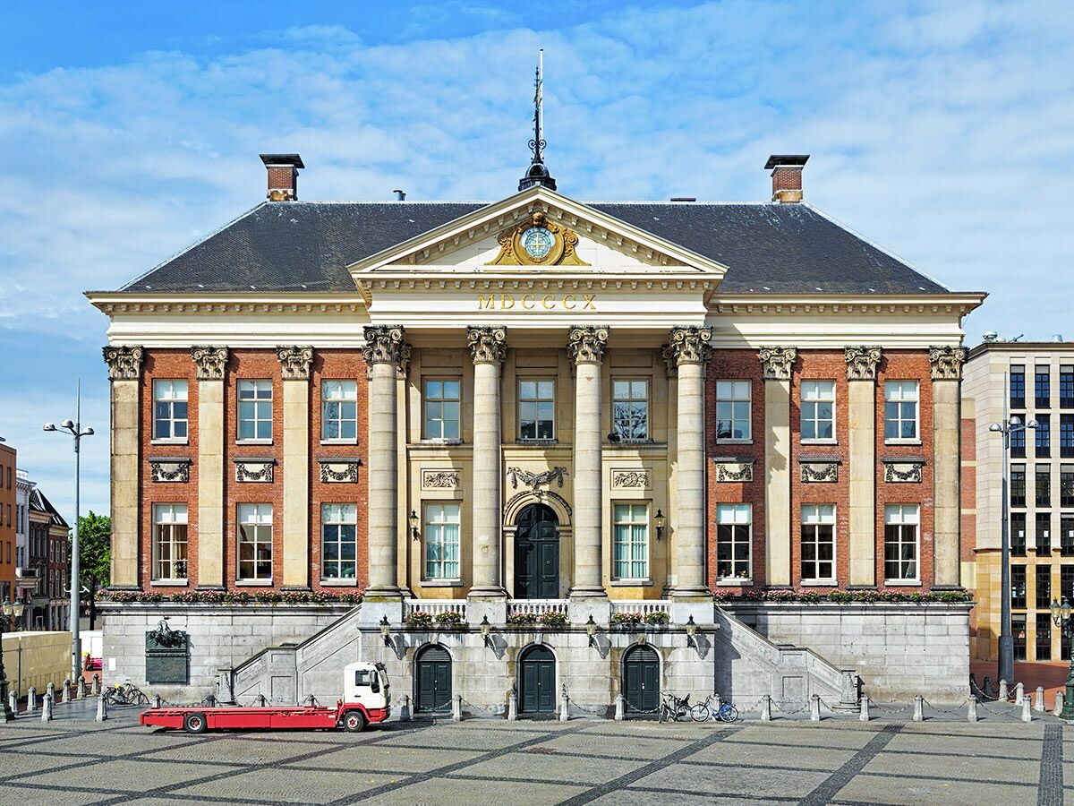 Historisches Stadhuis Leiden mit klassizistischer Fassade, Säulen, Uhr und Platz, ein LKW davor.