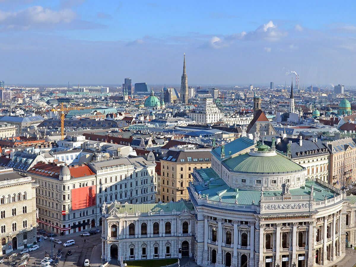 Panoramablick über Wien mit Burgtheater, Stephansdom, historischen Gebäuden und Skyline bei Tageslicht.