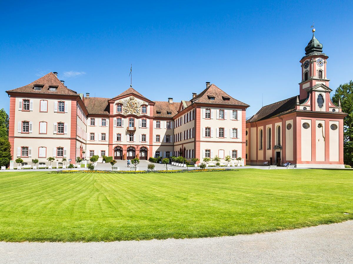 Historisches Schloss und ehemaliges Kloster Salem mit Kirche und Grünanlage unter blauem Himmel in Baden-Württemberg.