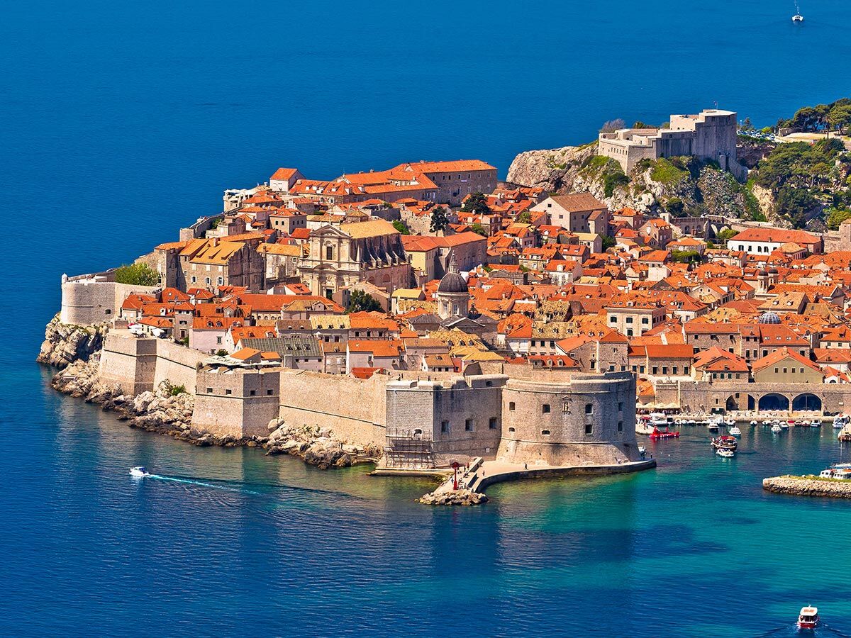 Luftbild der historischen Altstadt von Dubrovnik, Kroatien, mit roten Dächern, Stadtmauern und dem blauen Adriatischen Meer.