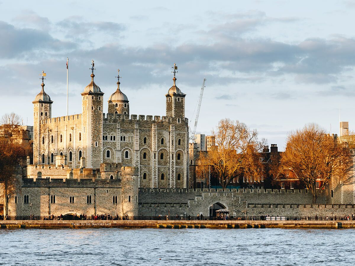 Historischer Tower of London mit Themse-Fluss, mittelalterliche Burg im warmen Sonnenlicht, London.