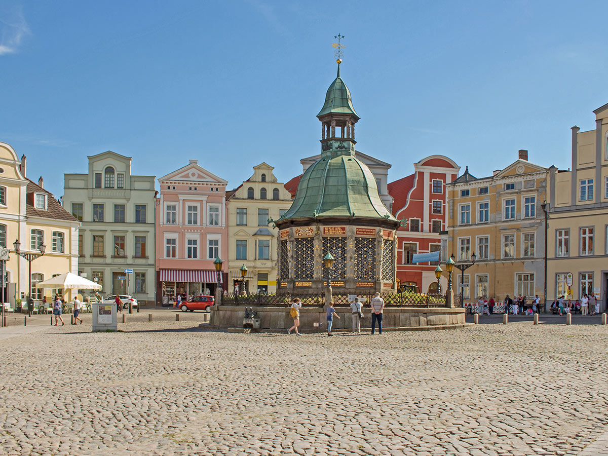 warnemuende-urlaub-zwischen-leuchttuermen-und-sandstraenden-wismar-marktplatz-mit-brunnen-127600709.jpg