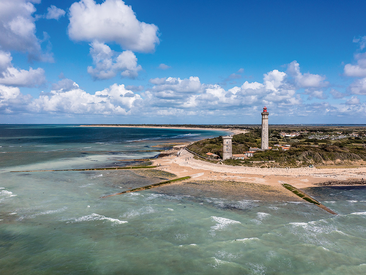Luftaufnahme des Phare des Baleines Leuchtturms auf Île de Ré, Frankreich, mit Meer, Strand und altem Turm.
